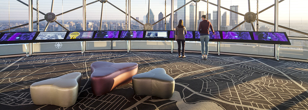 Visitors interact with the touchscreens on Reunion Tower's observation deck.