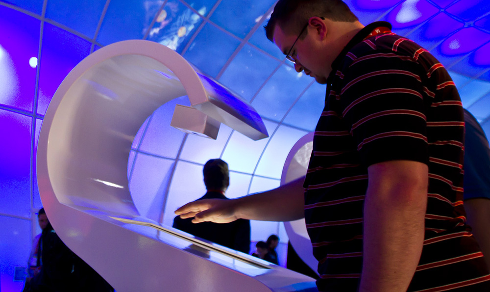 Person scanning hand at interactive station