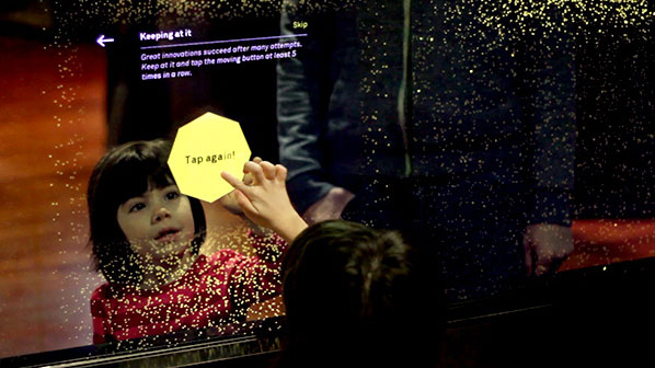 A child learns that persistence is a key trait of innovation on an interactive touch wall.